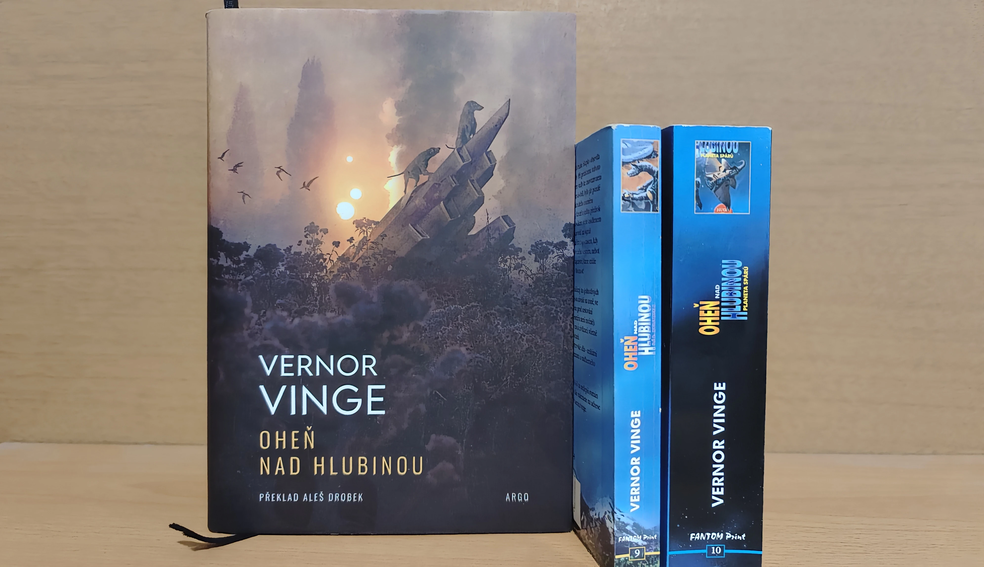 Nové vydanie Ohňa nad Hlubinou (Argo, 2025) spolu so starými paperbackami (Fantom Print, 2000) 